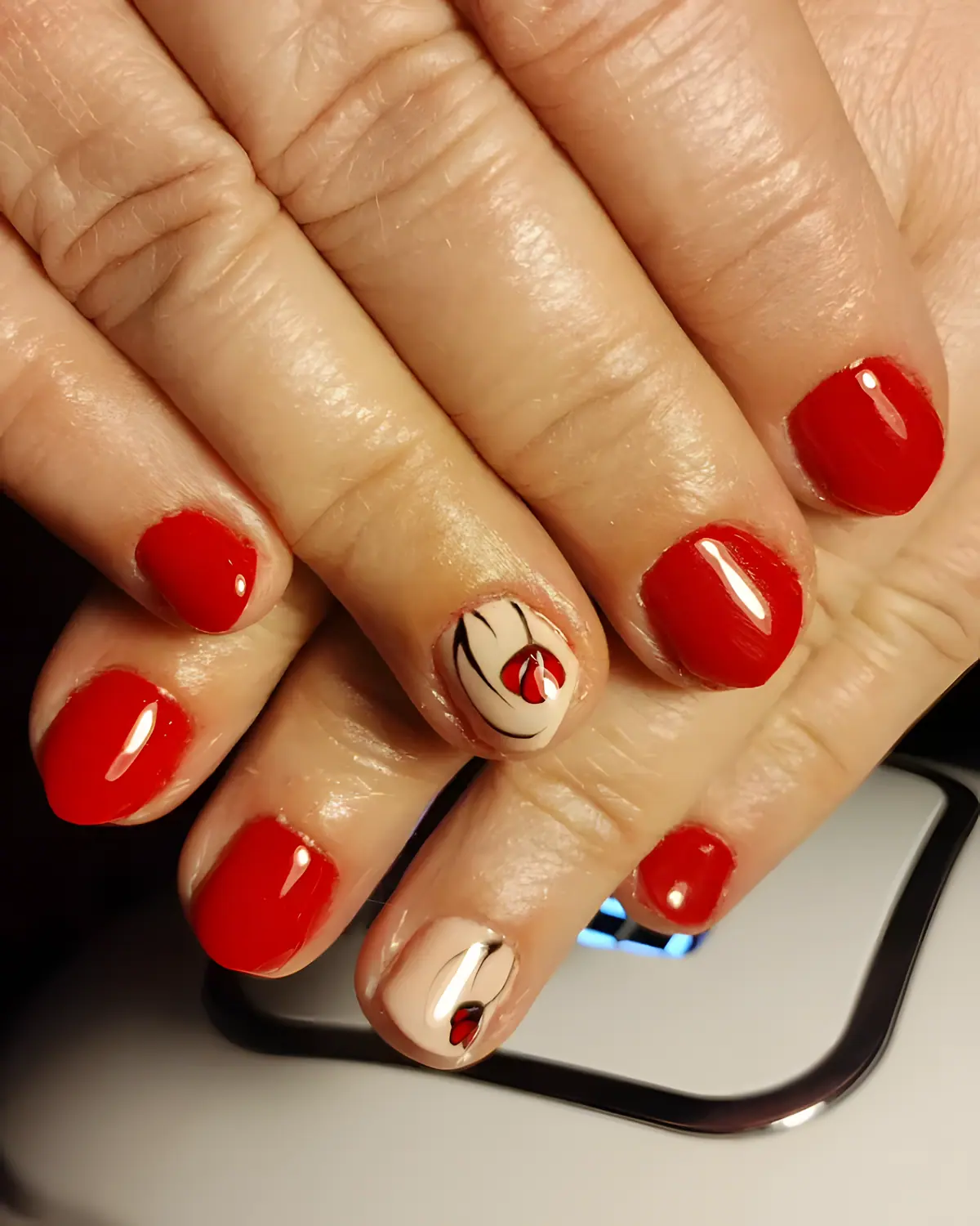 Uñas rojas con una amapola pintada a mano